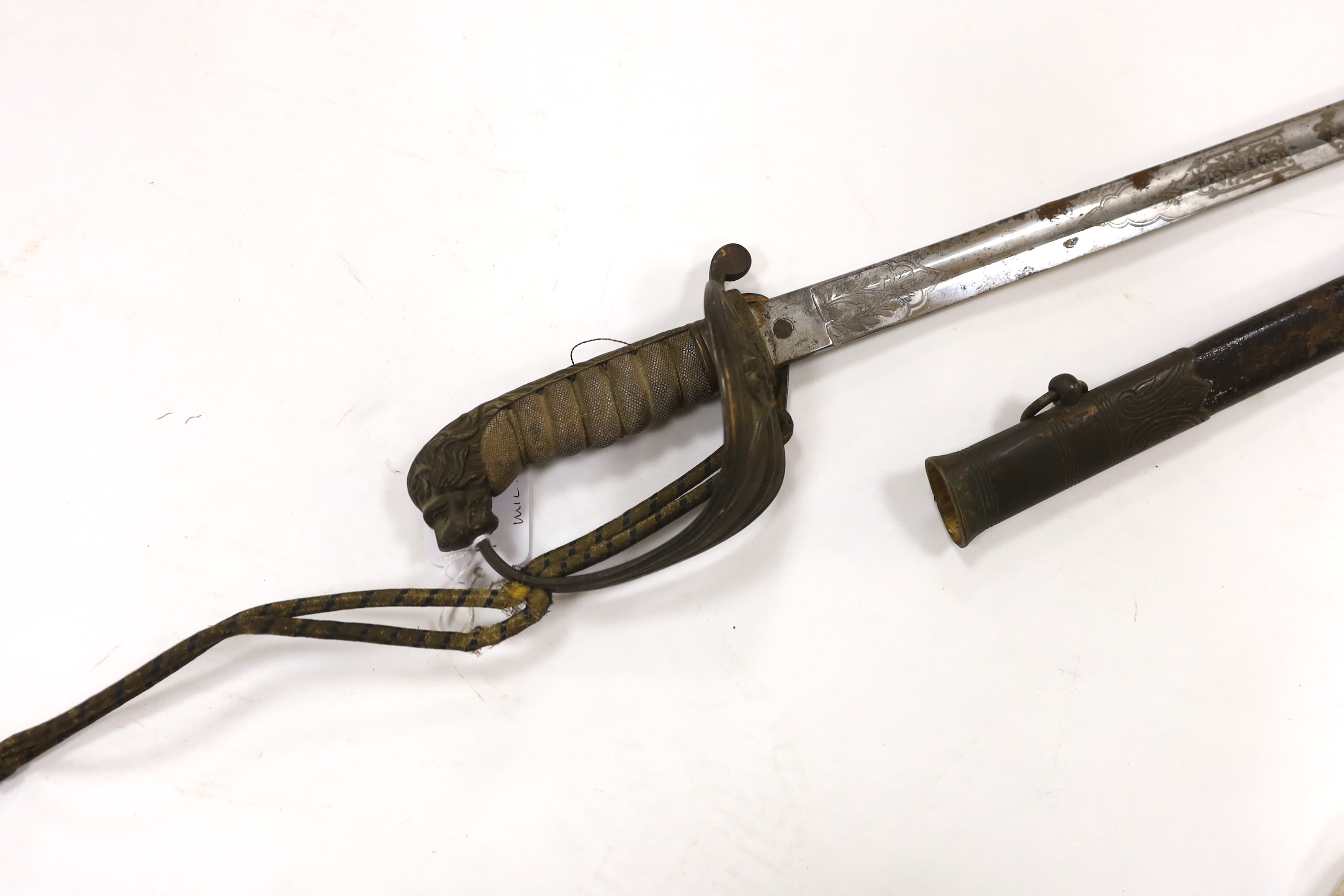 A late Victorian naval officer’s sword of the Royal Naval Reserve, regulation hilt with folding guard and bullion dress knot, in its leather scabbard with brass mounts